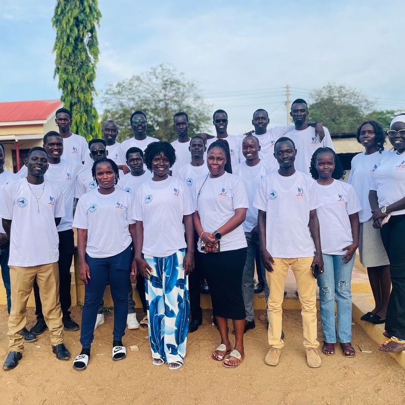 Build Your Best Self fellows in matching white T-shirts stand together in rows outdoors
