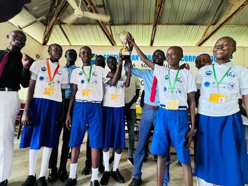 Pupils of Jada Jedid in blue and white uniforms hold up their trophy after the debate final