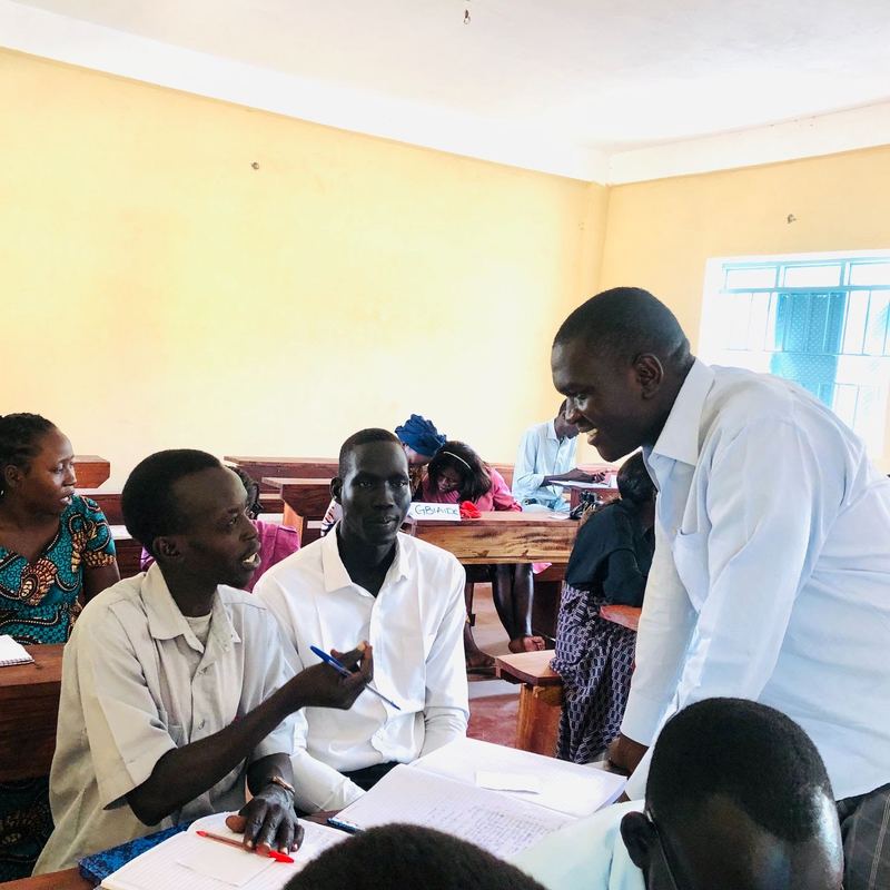 Teachers work in small groups at desks during an in-service workshop