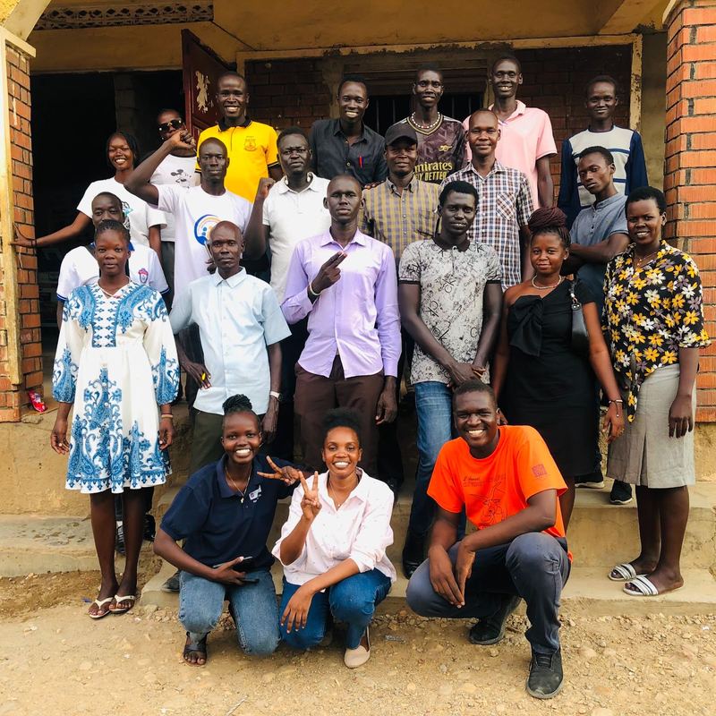 Teachers and Excellence Foundation volunteers pose together outside a school after a teachers' skills workshop